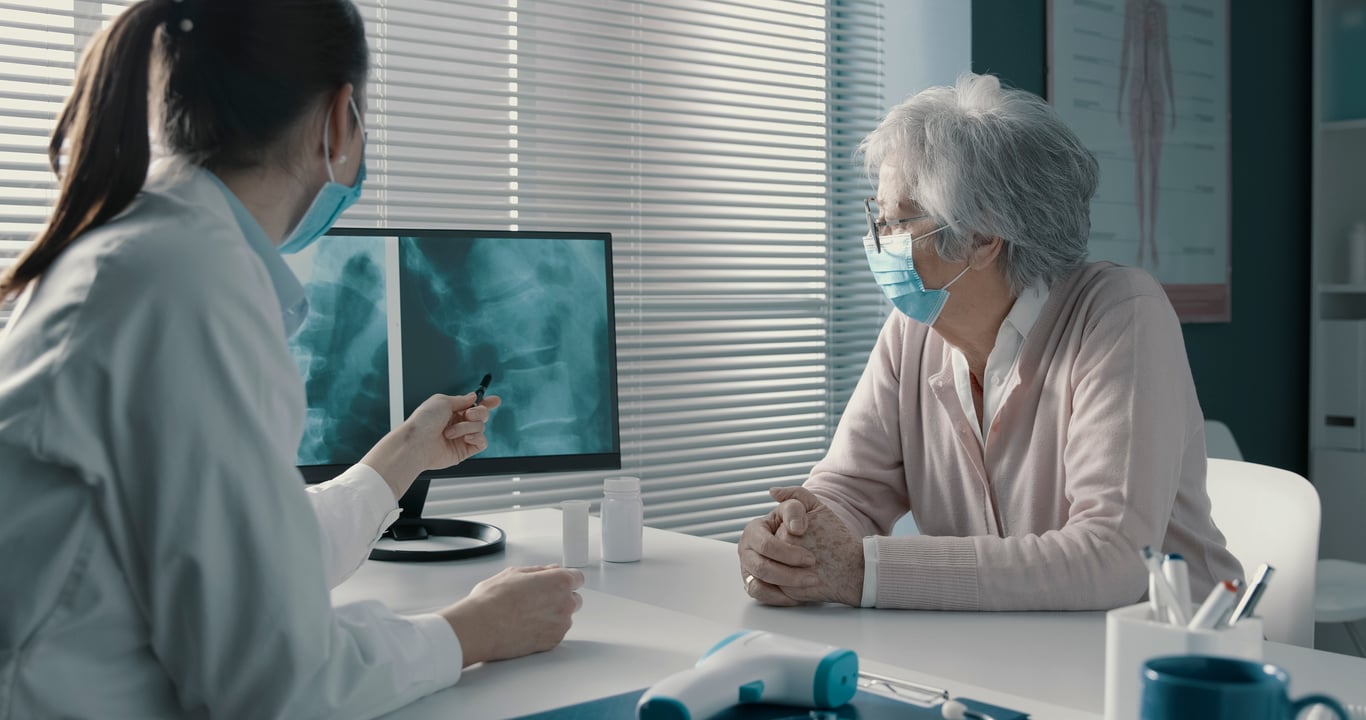 doctor-checking-an-x-ray-image-with-a-patient-2022-10-22-02-41-15-utc